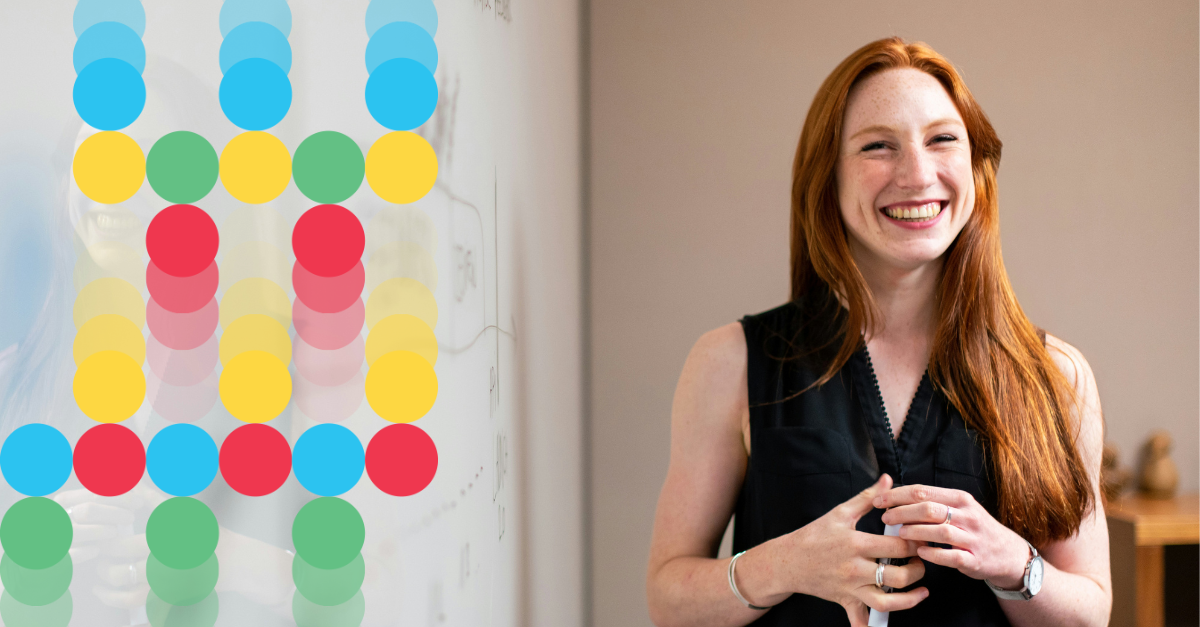 Woman smiling by a whiteboard in an office