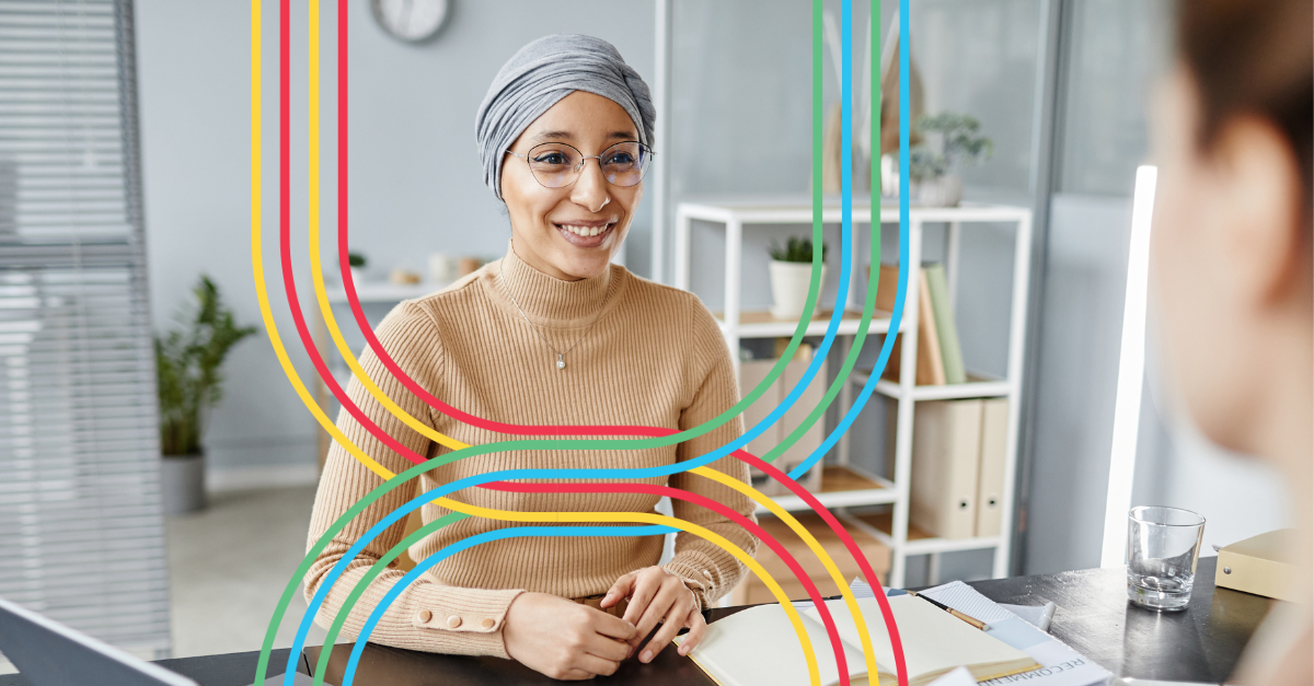 Woman smiling and chatting with another team member in an office