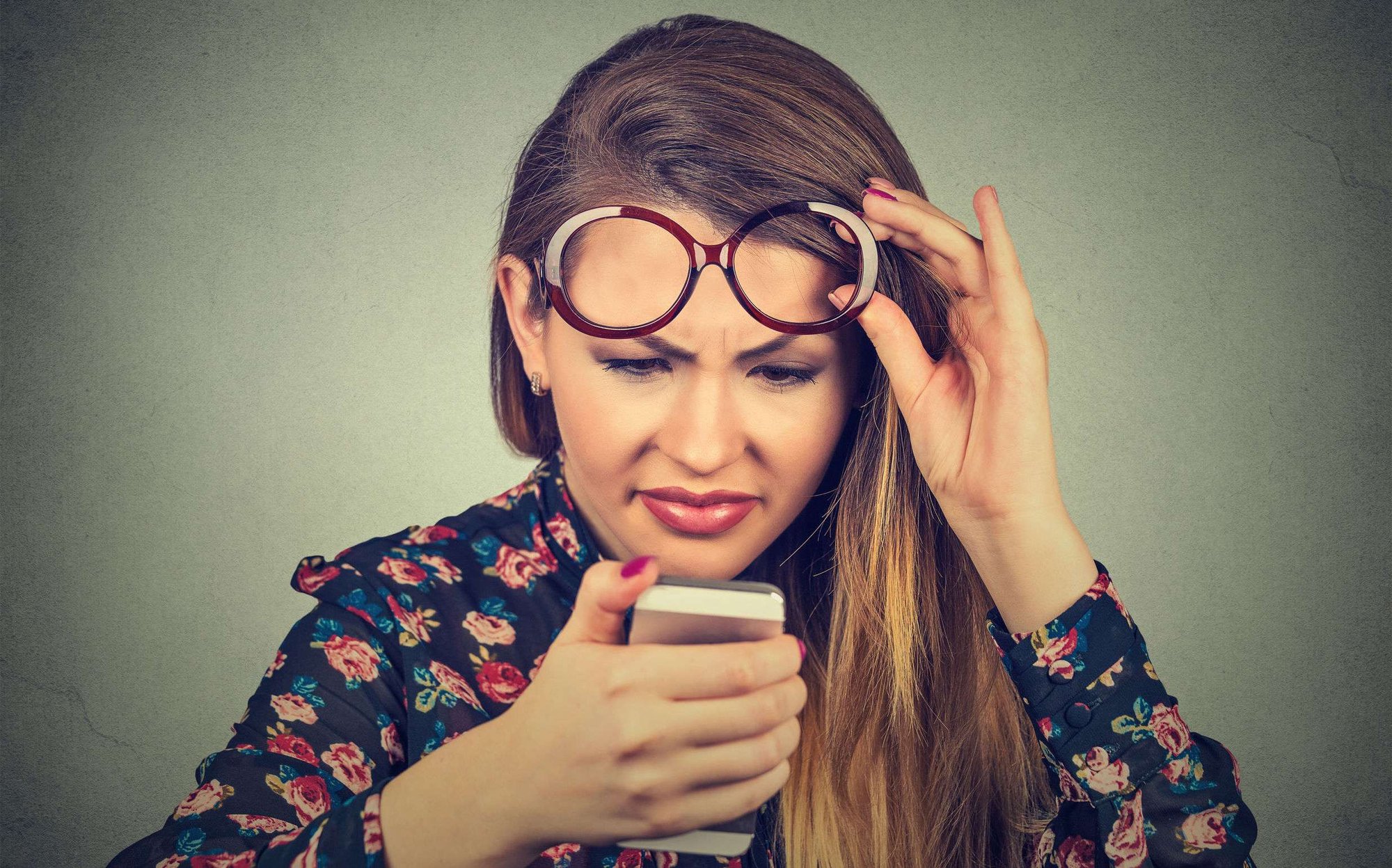 Woman looking at her phone confused