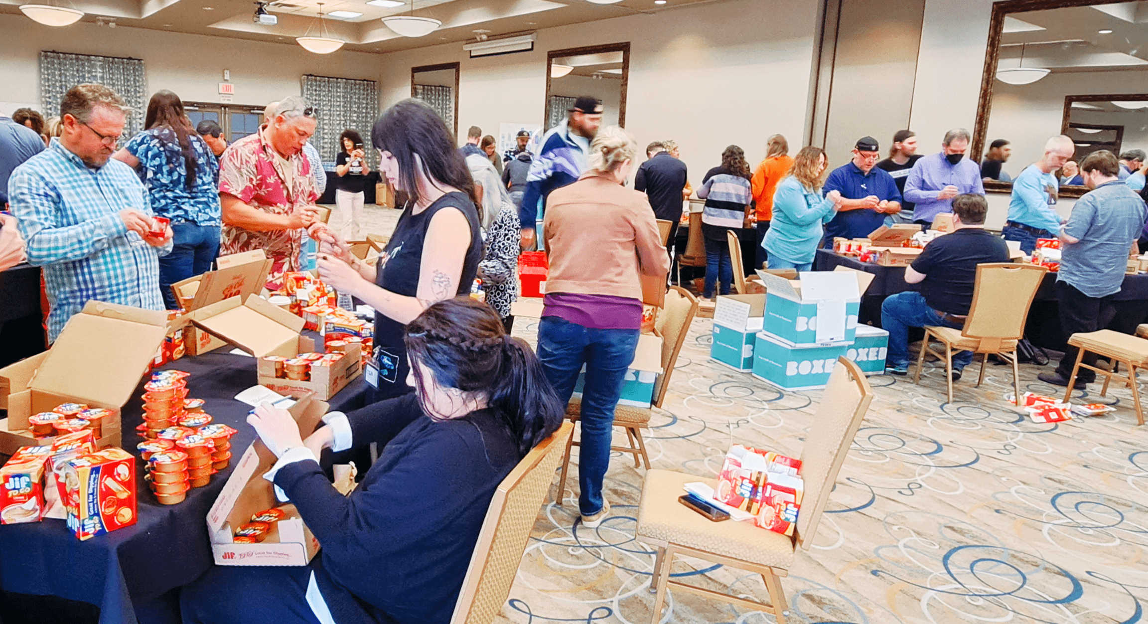 Team members packaging peanut butter and canned goods together
