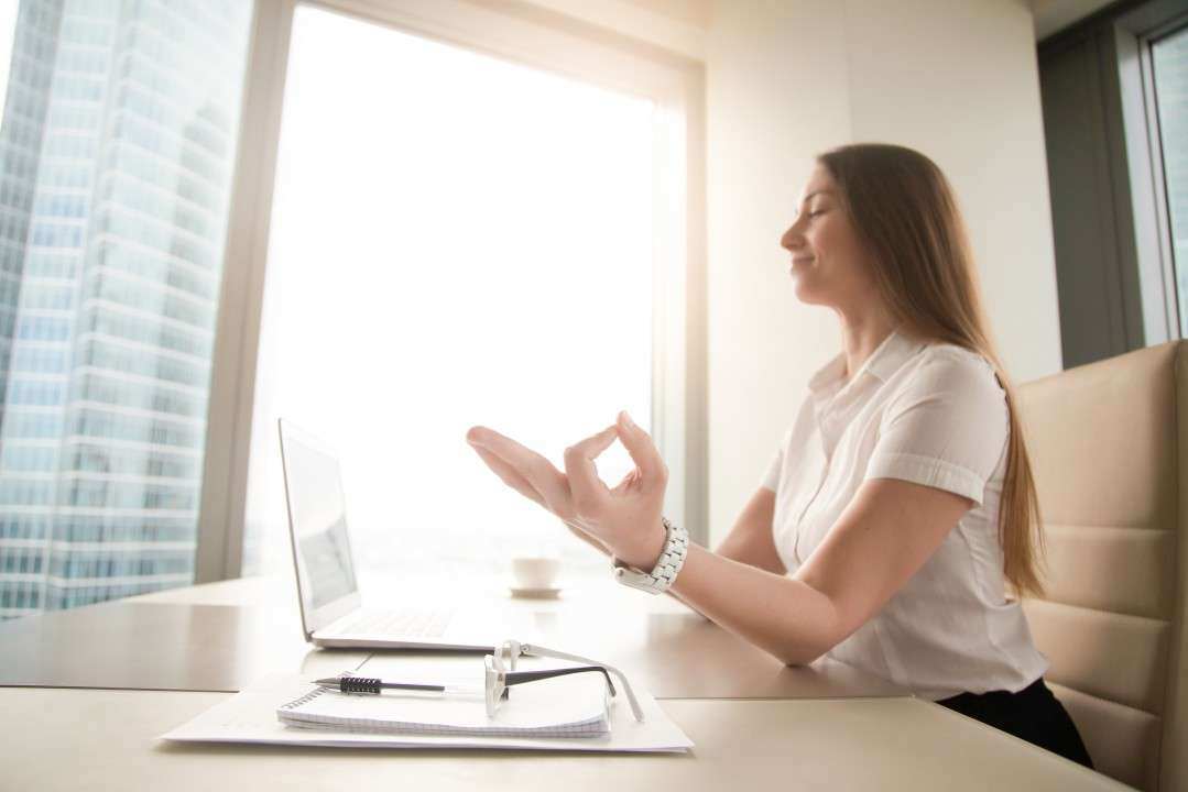 Woman meditating in her office