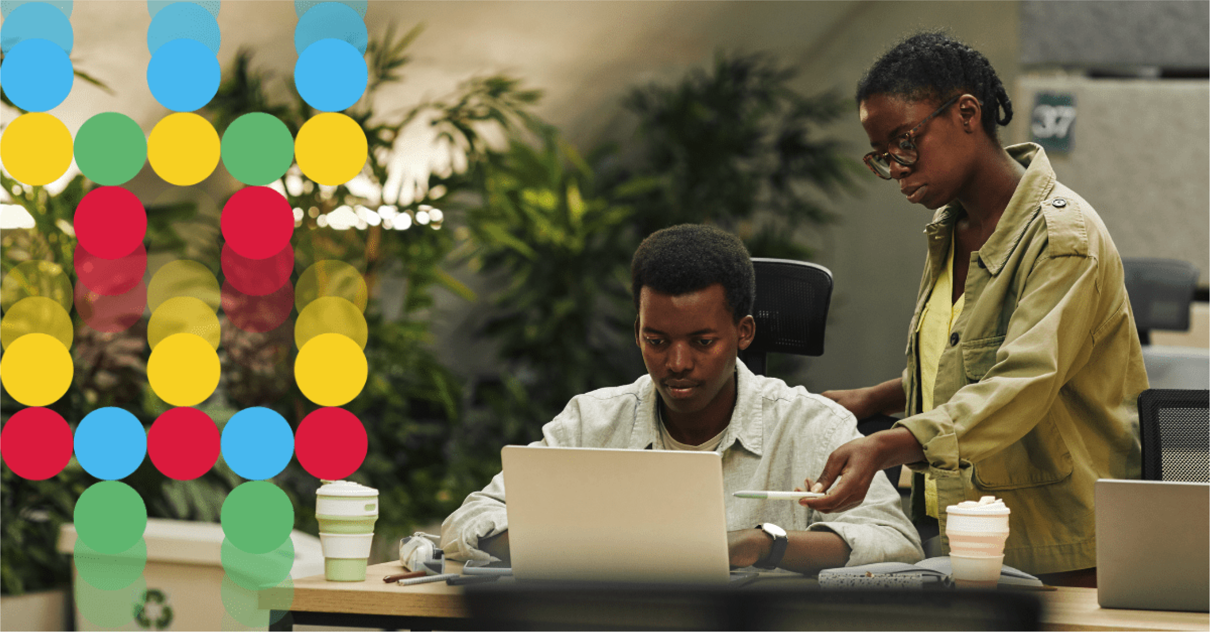 Two team members viewing a laptop in an office